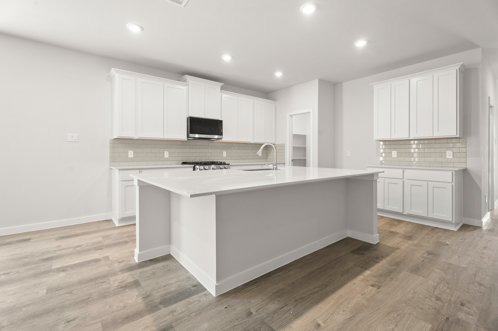 A kitchen with white cabinets.