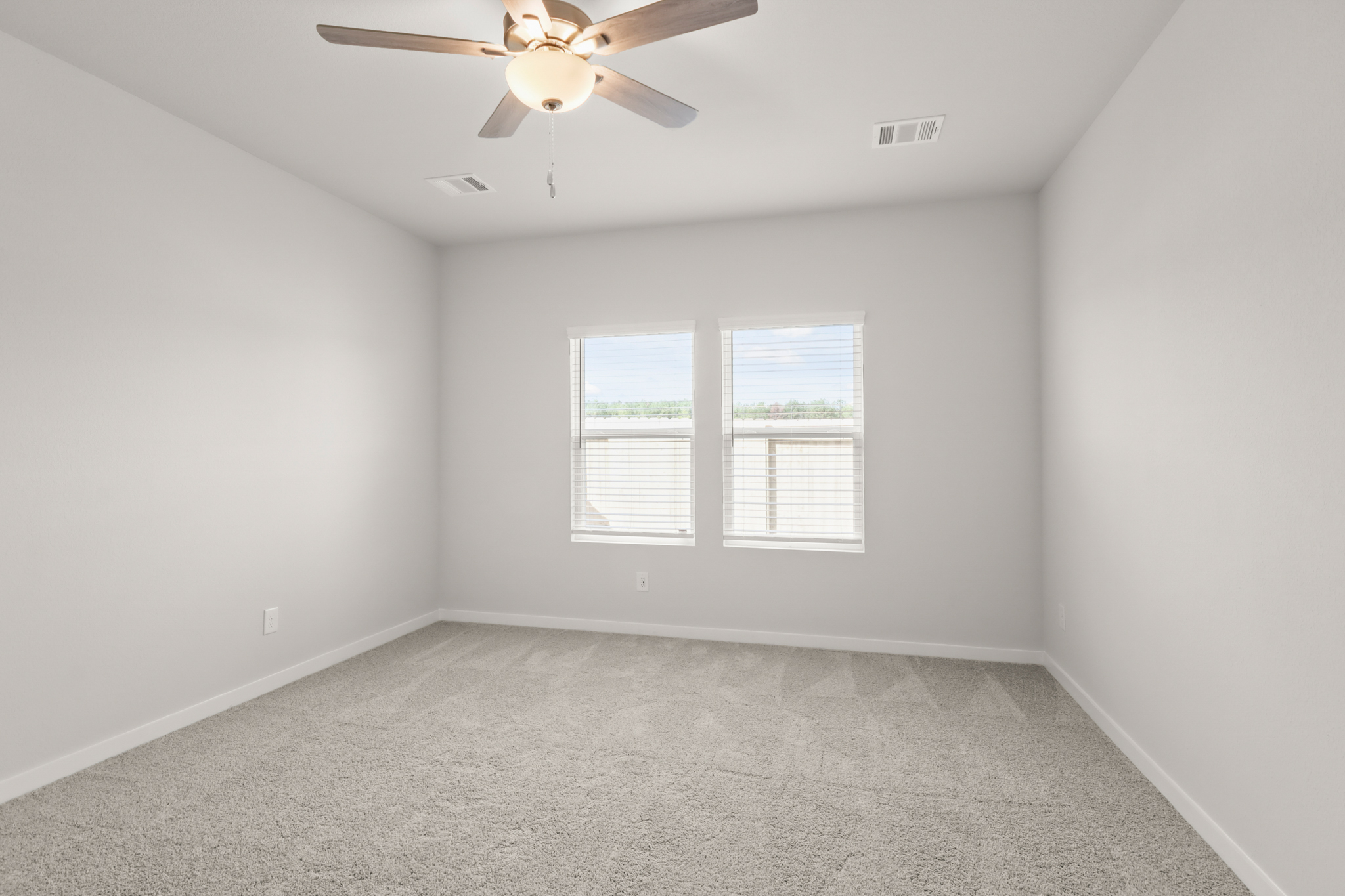 A room with a ceiling fan and a window.