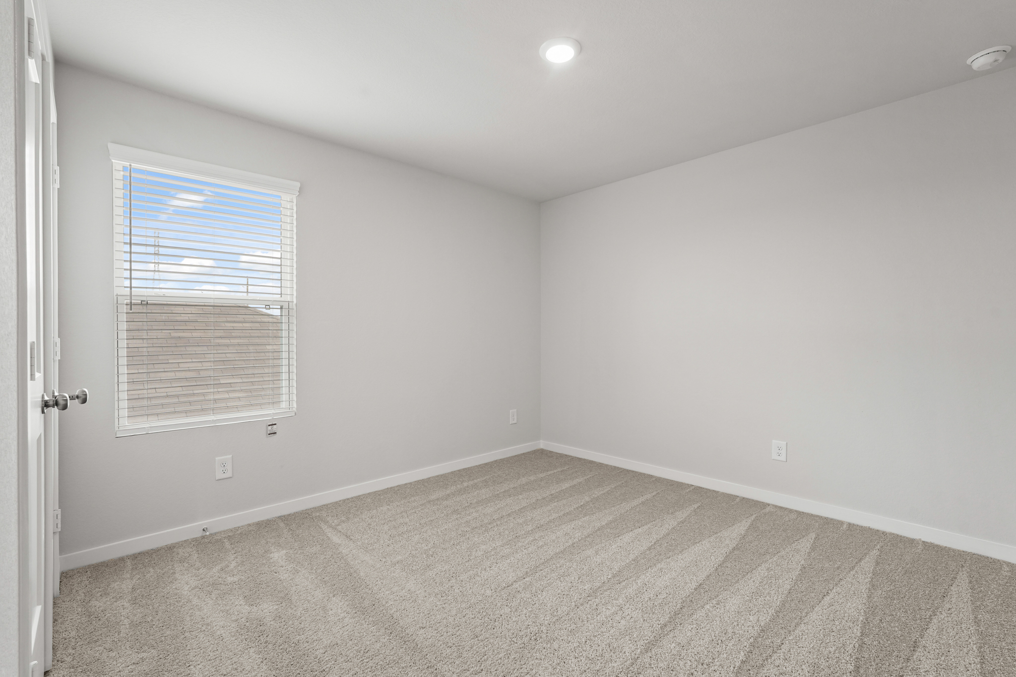 A room with a window and a rug.