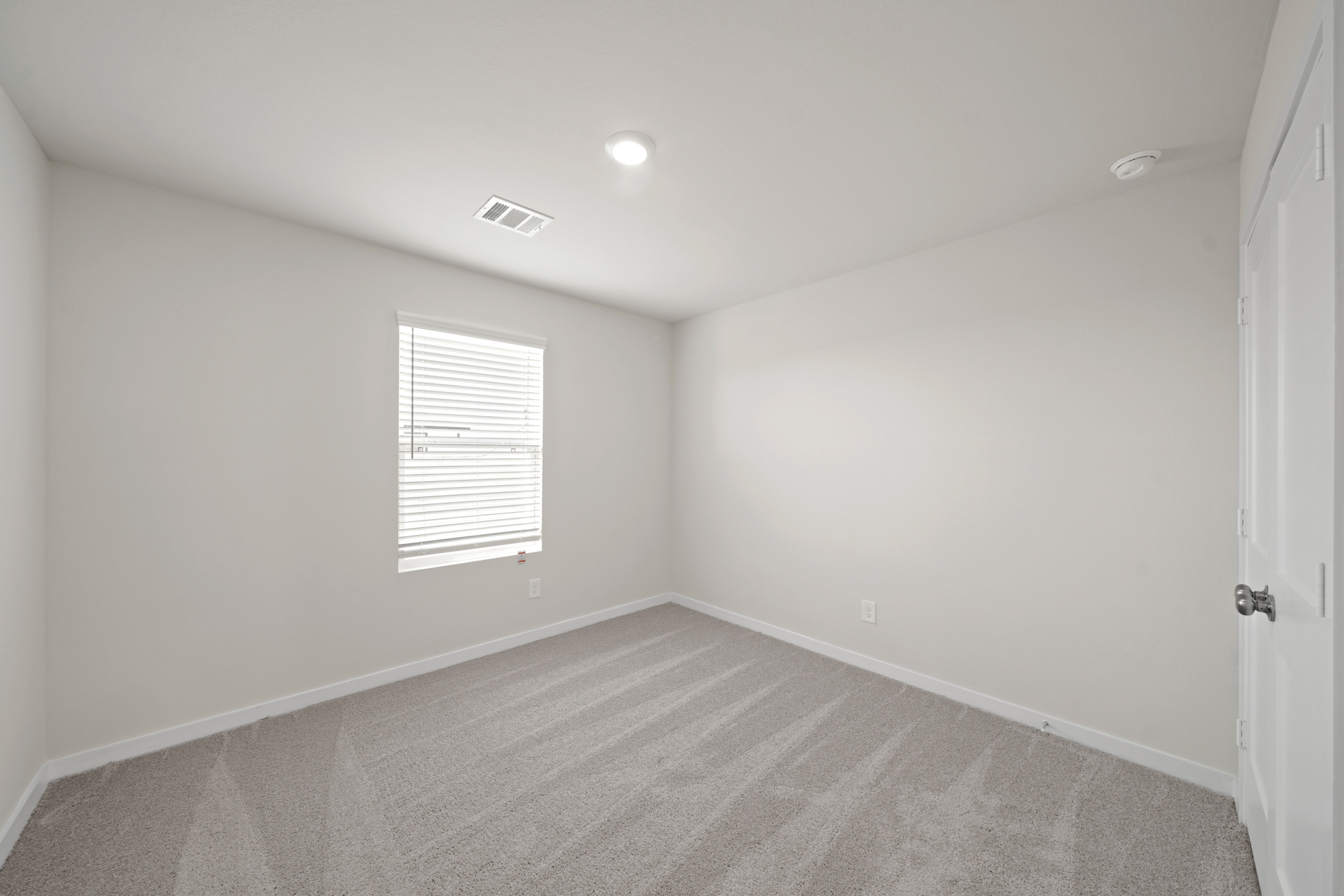 A room with a carpet and a window.