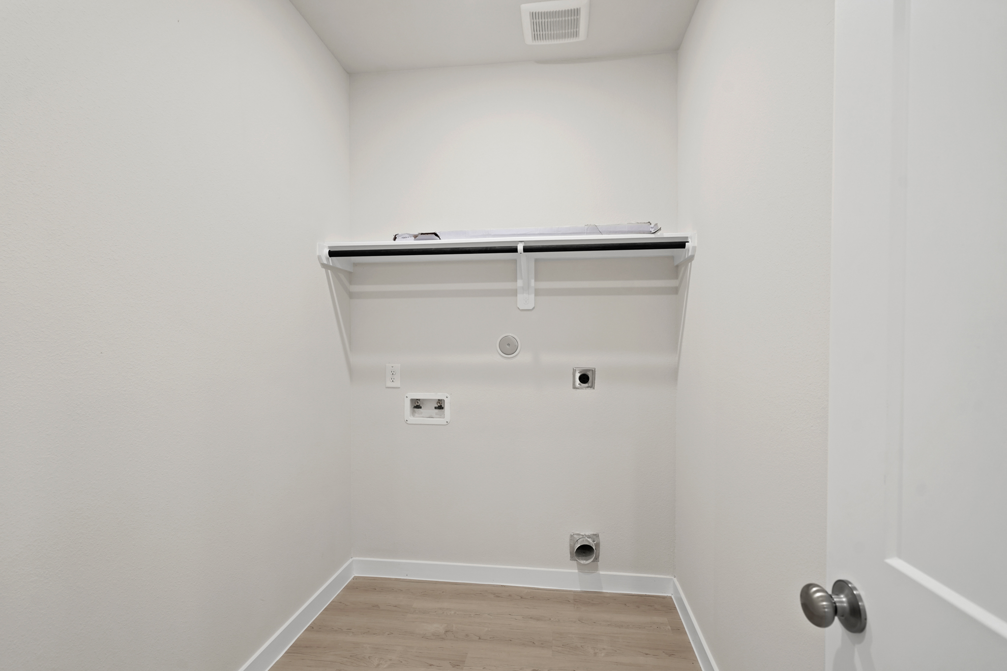 A white wall with a metal bar.