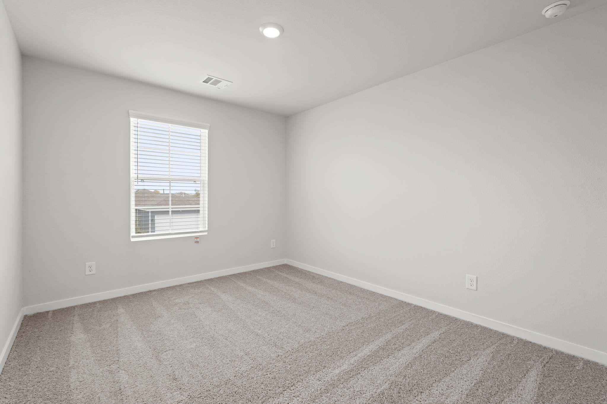 A room with a window and a carpet.