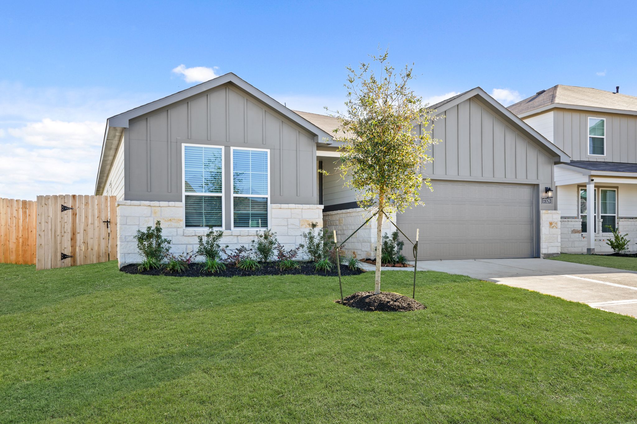 A house with a tree in the front yard.
