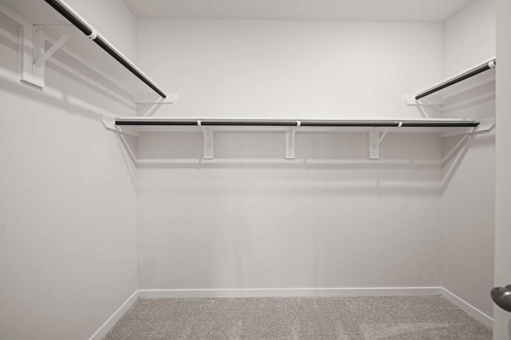 A white wall with a metal railing.