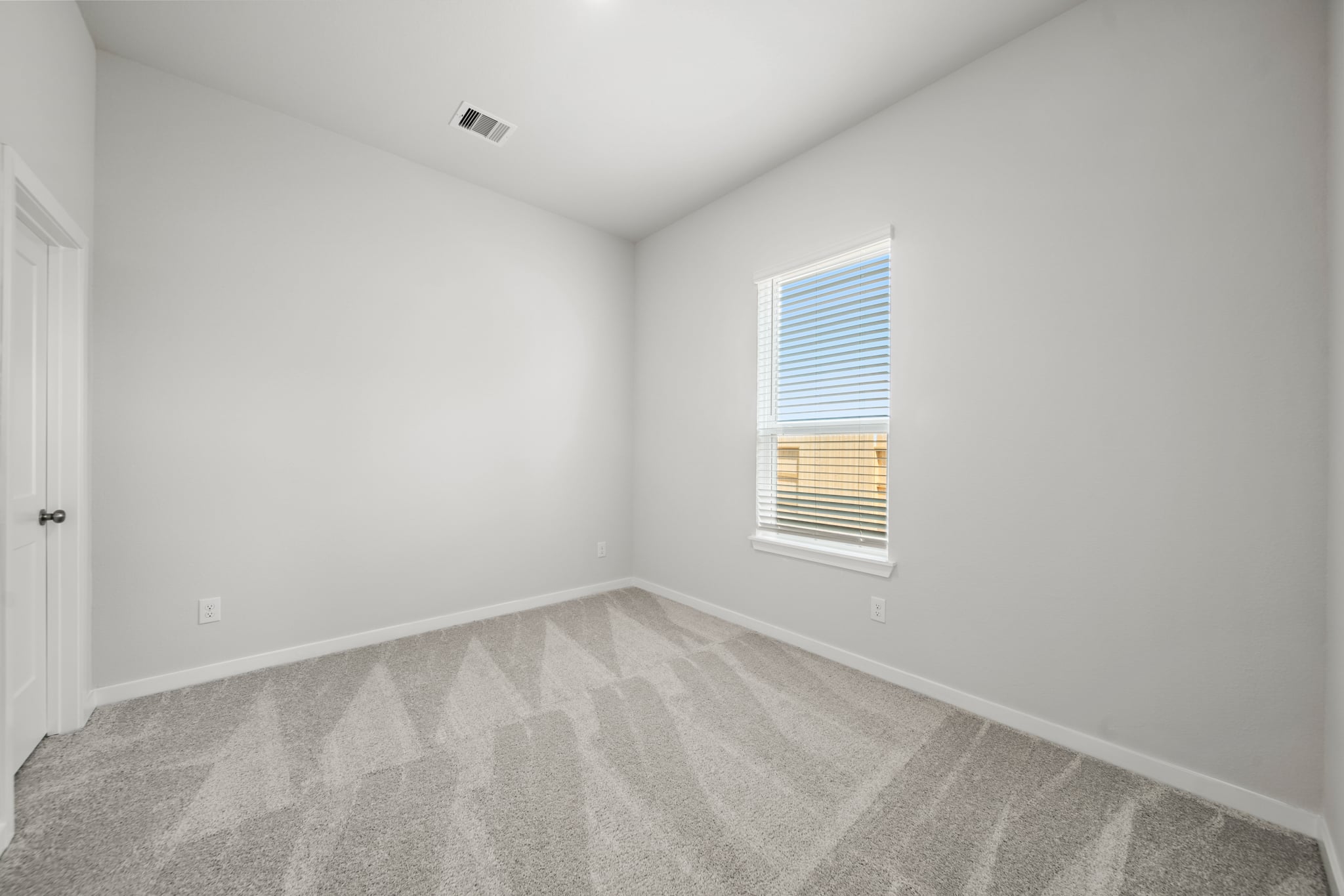 A room with a carpet and a window.