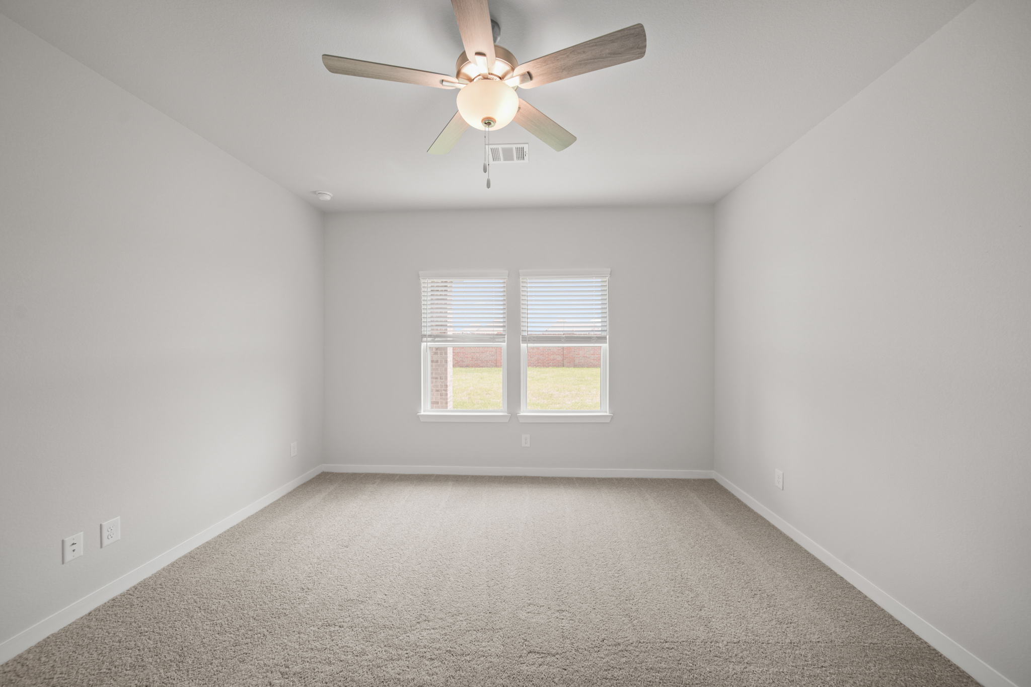 A room with a ceiling fan and a window.