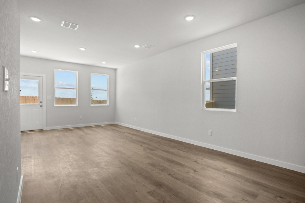 A room with a wood floor and windows.