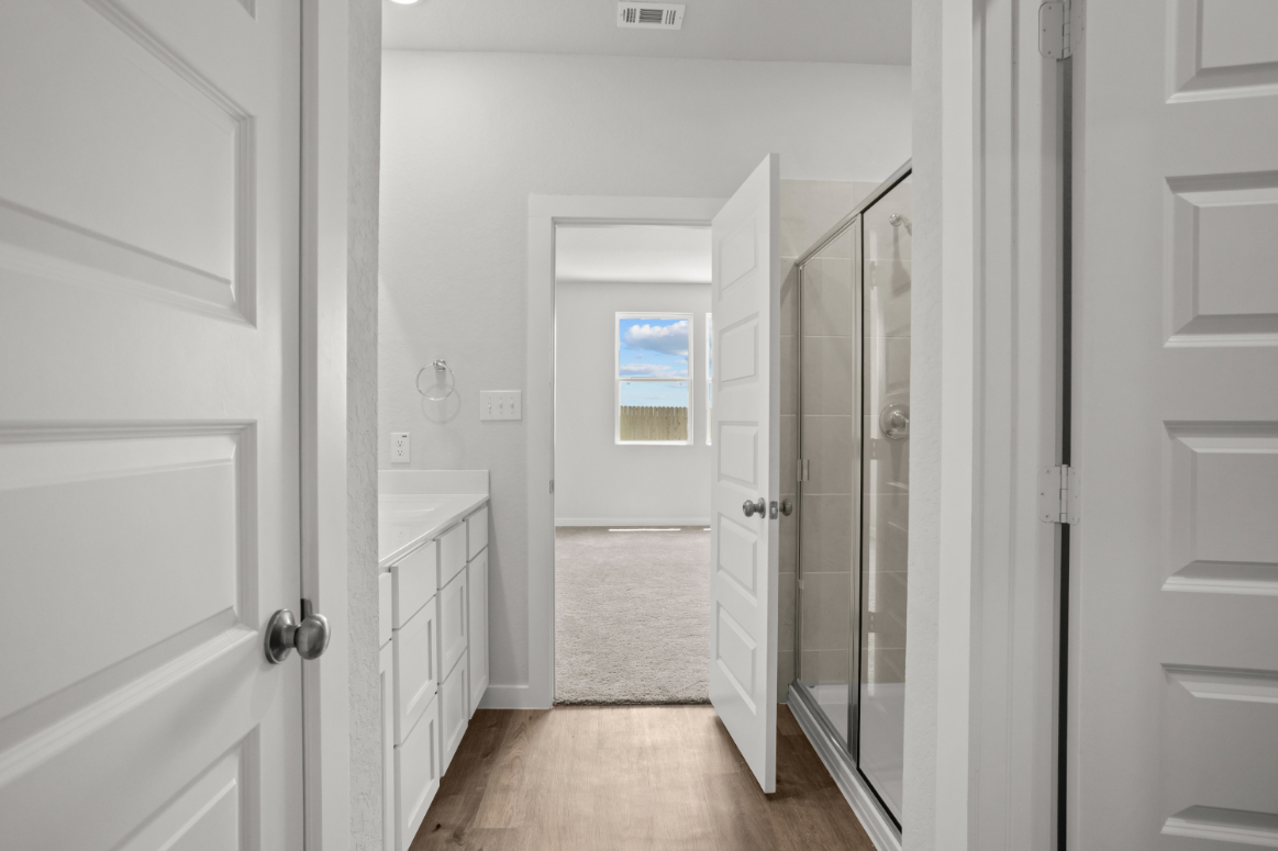 A bathroom with white cabinets.