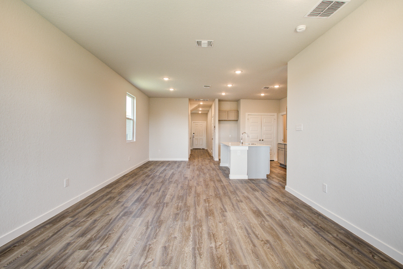 A room with white walls and wood floors.