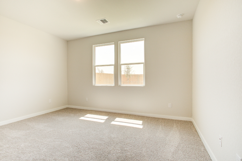 A room with a window and a carpet.