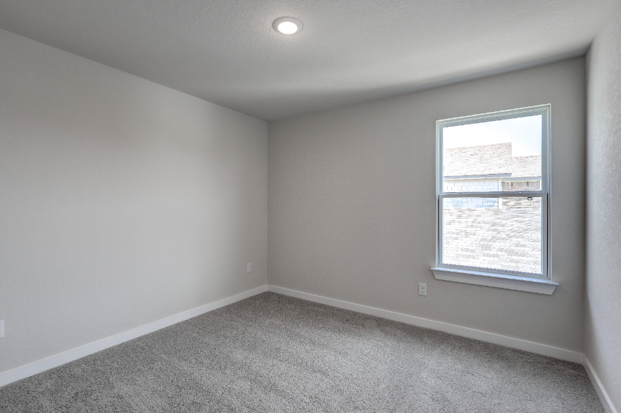 A room with a window and a carpet.