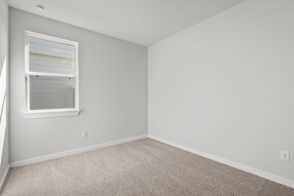 A room with a window and carpet.