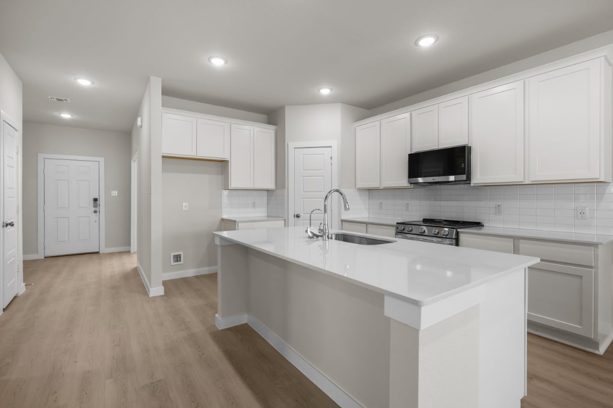 A kitchen with white cabinets.