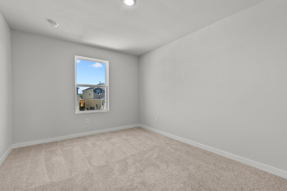 A room with a window and a carpet.