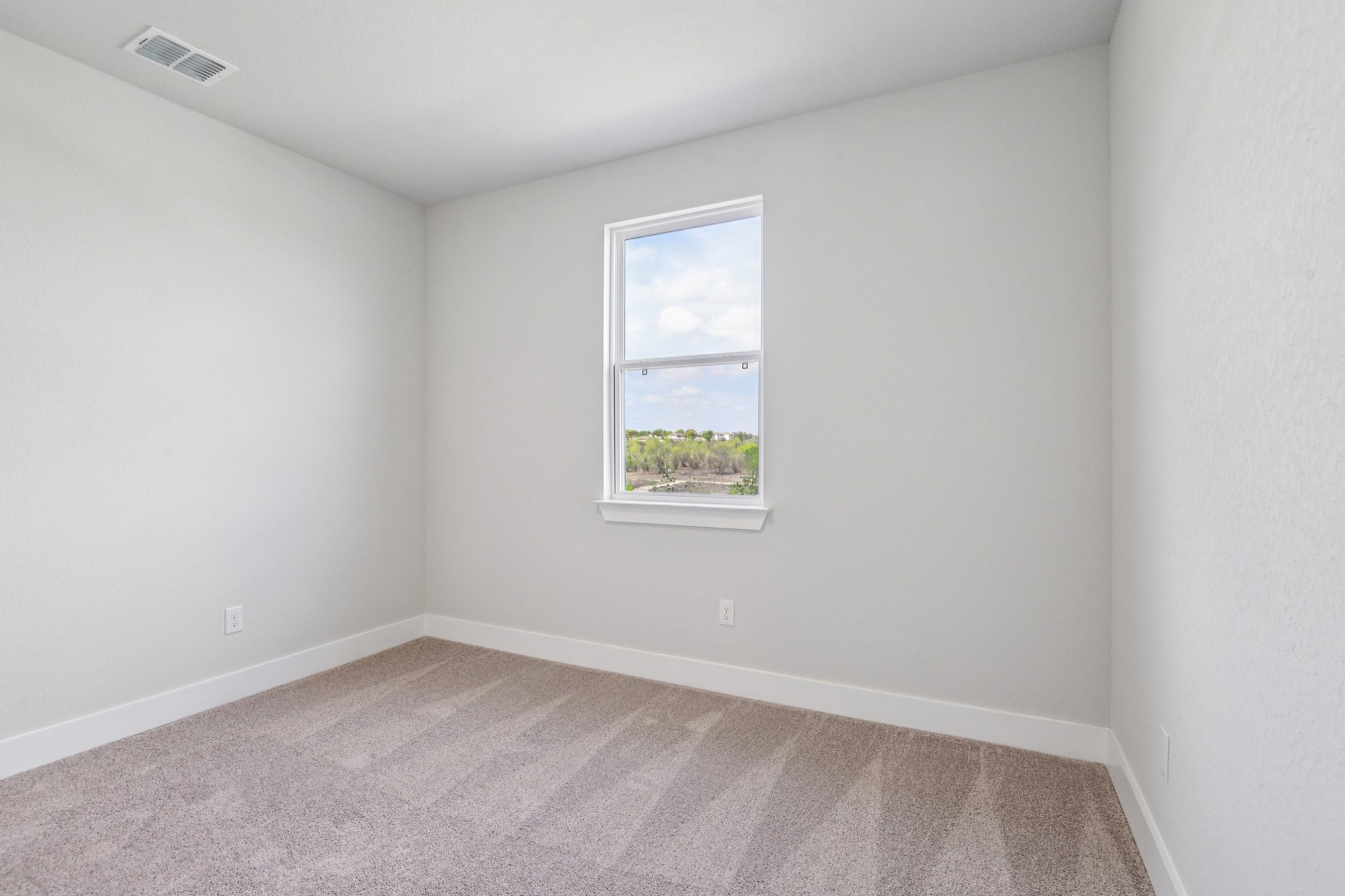 A room with a window and carpet.