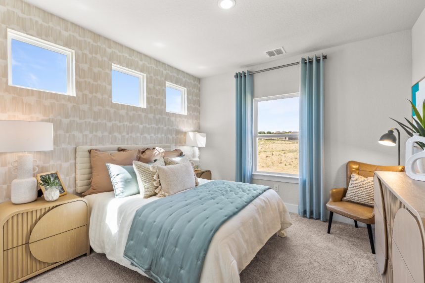 A bedroom with a bed and a chair.