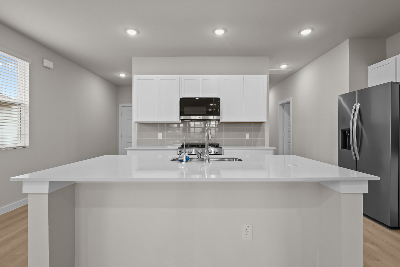 A kitchen with white cabinets.