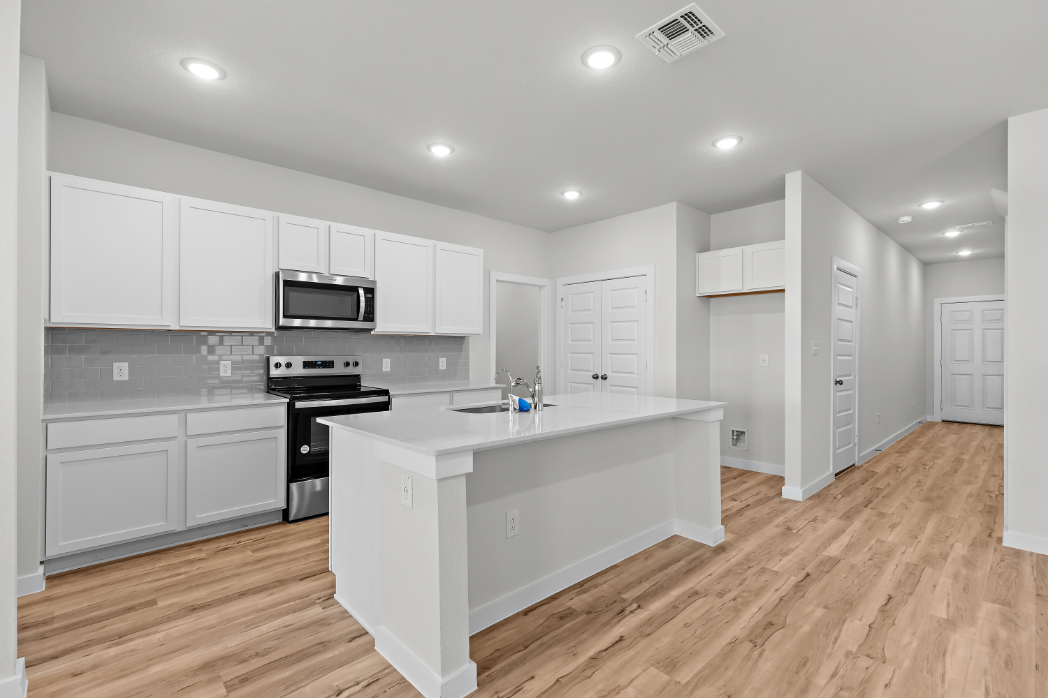 A kitchen with white cabinets.