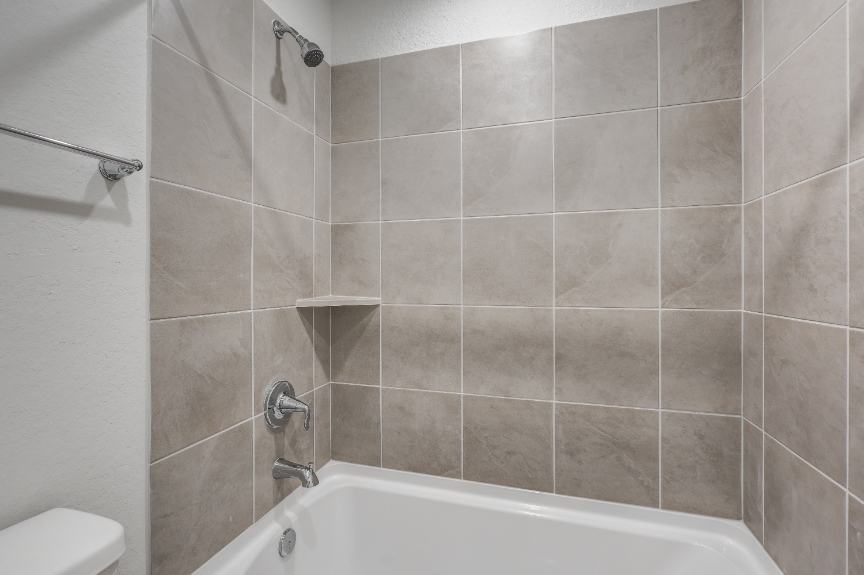 A bathroom with a bathtub and shower.