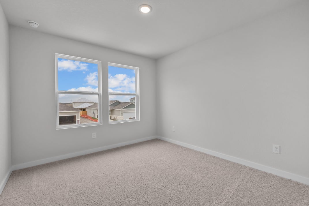 A room with a window and a painting on the wall.