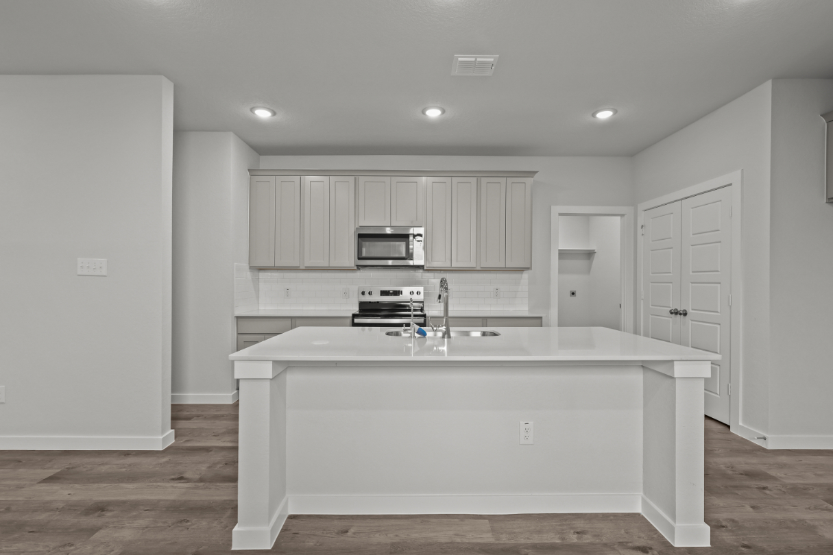 A kitchen with white cabinets.