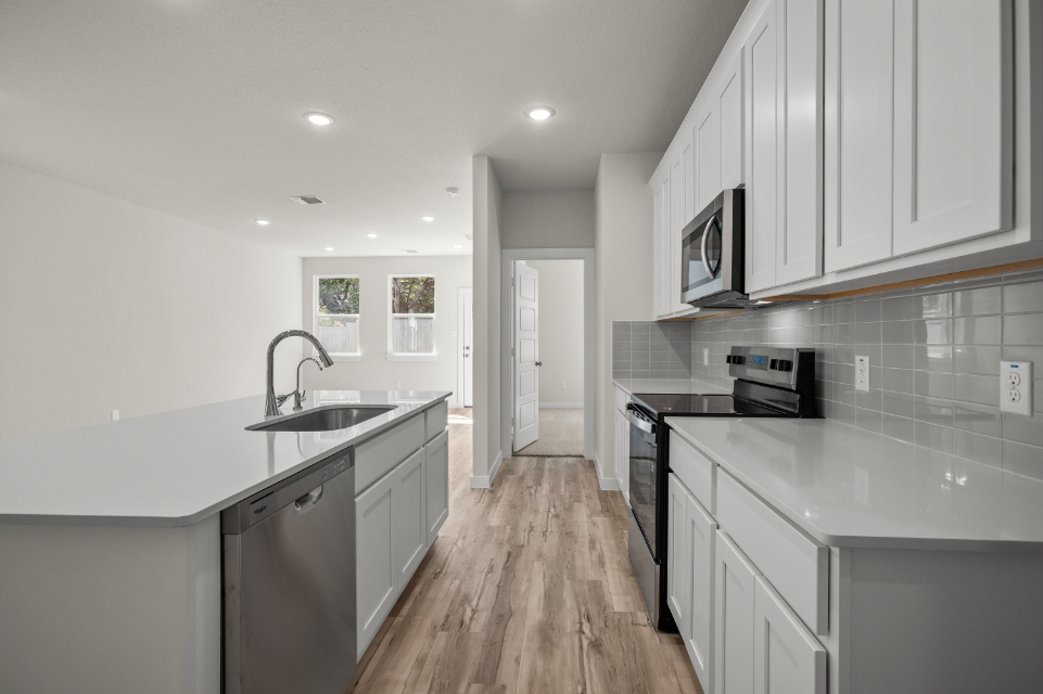 A kitchen with white cabinets.