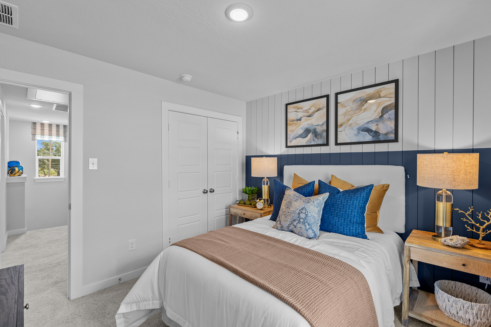 A bedroom with a bed and lamps.