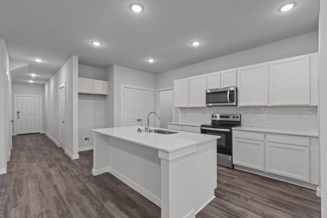 A kitchen with white cabinets.