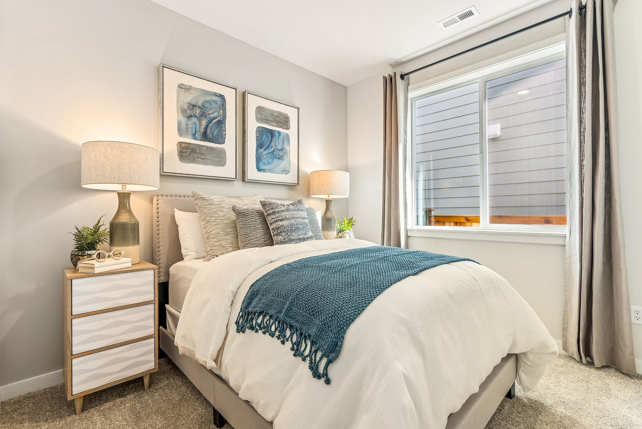 A bedroom with a bed and lamps.