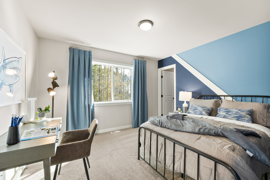 A bedroom with a bed and a desk.