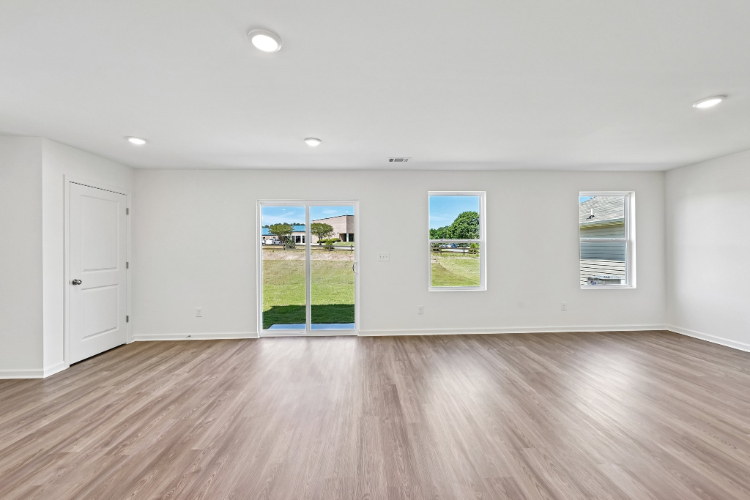A room with white walls and a wood floor with a wood floor.
