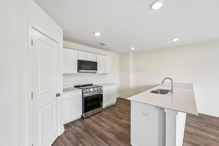 A kitchen with white cabinets.