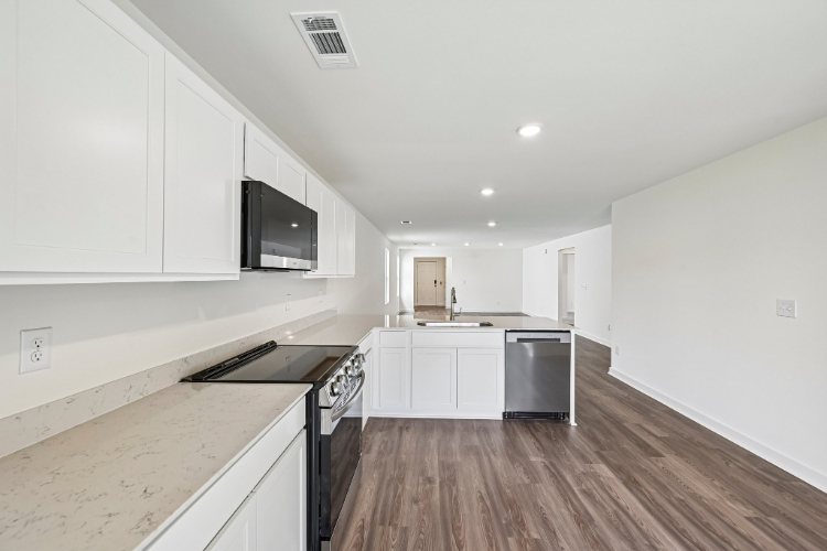 A kitchen with white cabinets.