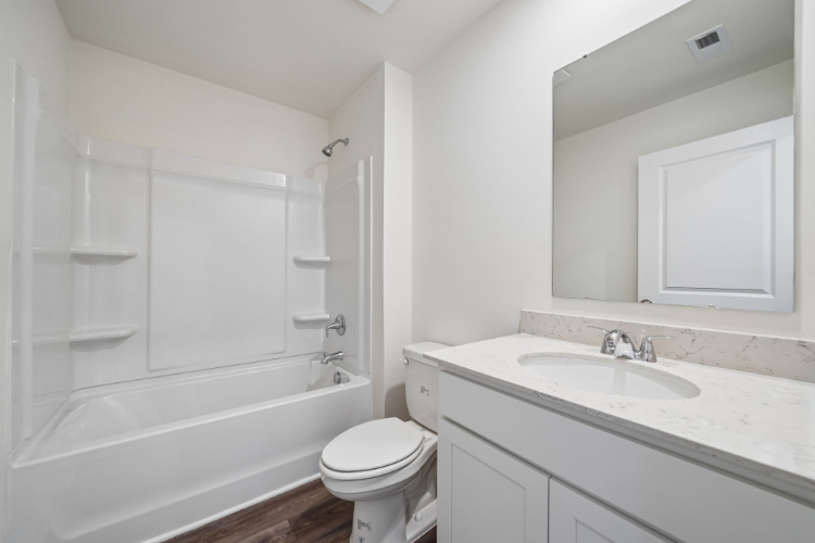 A bathroom with a tub sink and toilet.