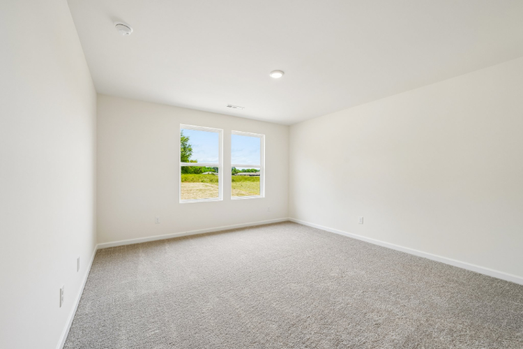 A room with a window and carpet.