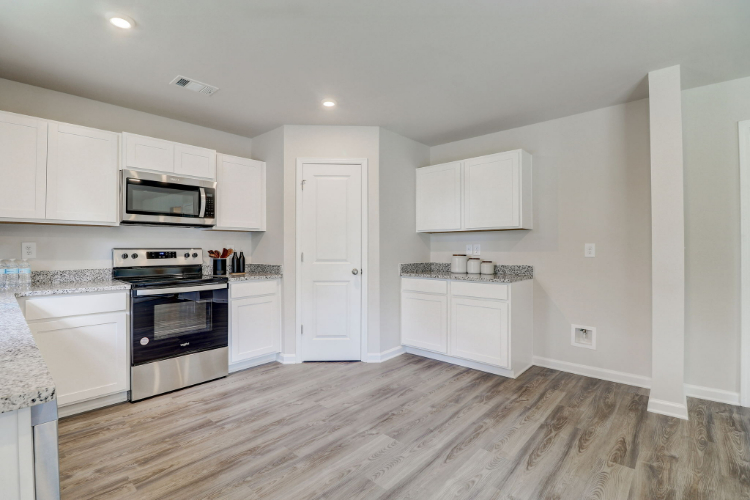 A kitchen with white cabinets.