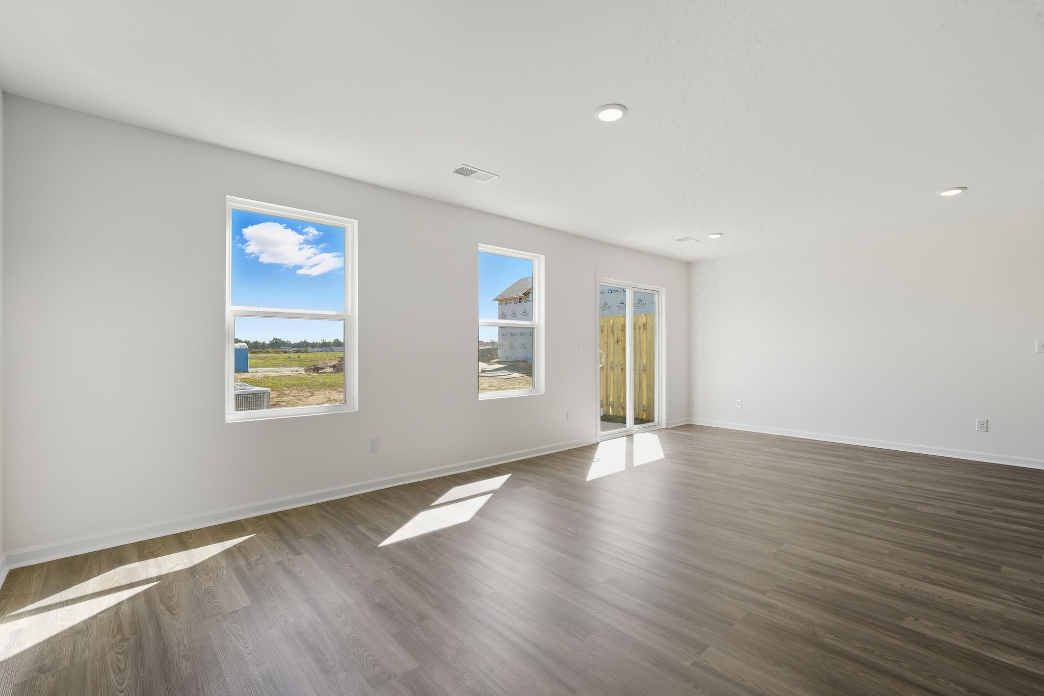 A room with a wood floor and a wood floor with a painting on the wall.