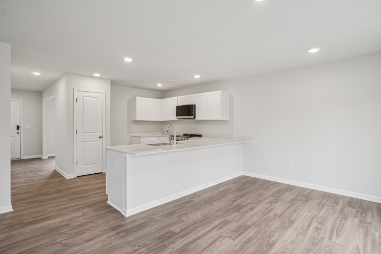A kitchen with white cabinets.