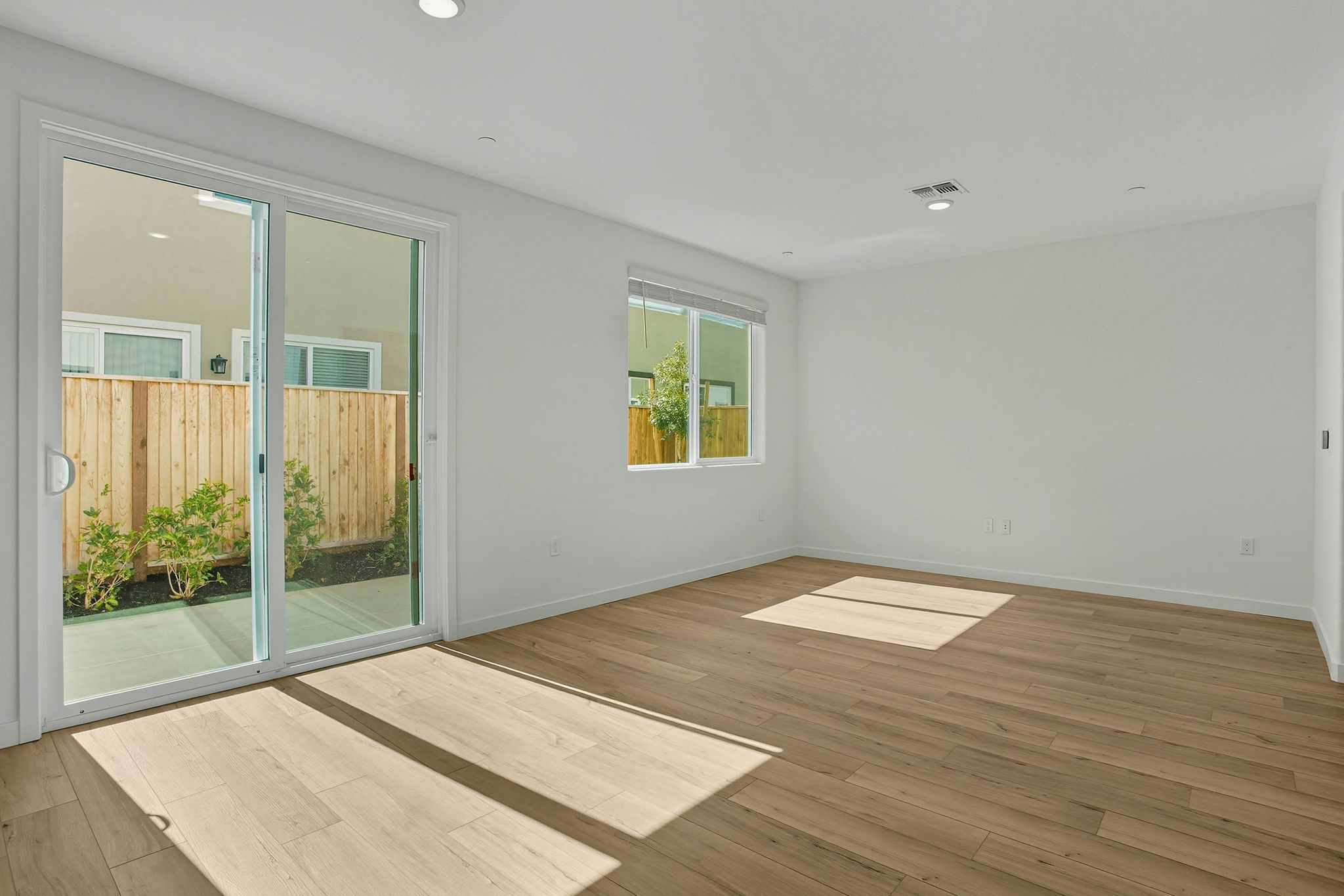 A room with a wood floor and a wood floor with a window.